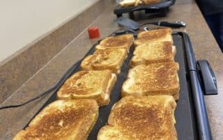 Team Leaders making grilled cheese for Team Members during DuraTech's annual Souper Bowl Lunch.